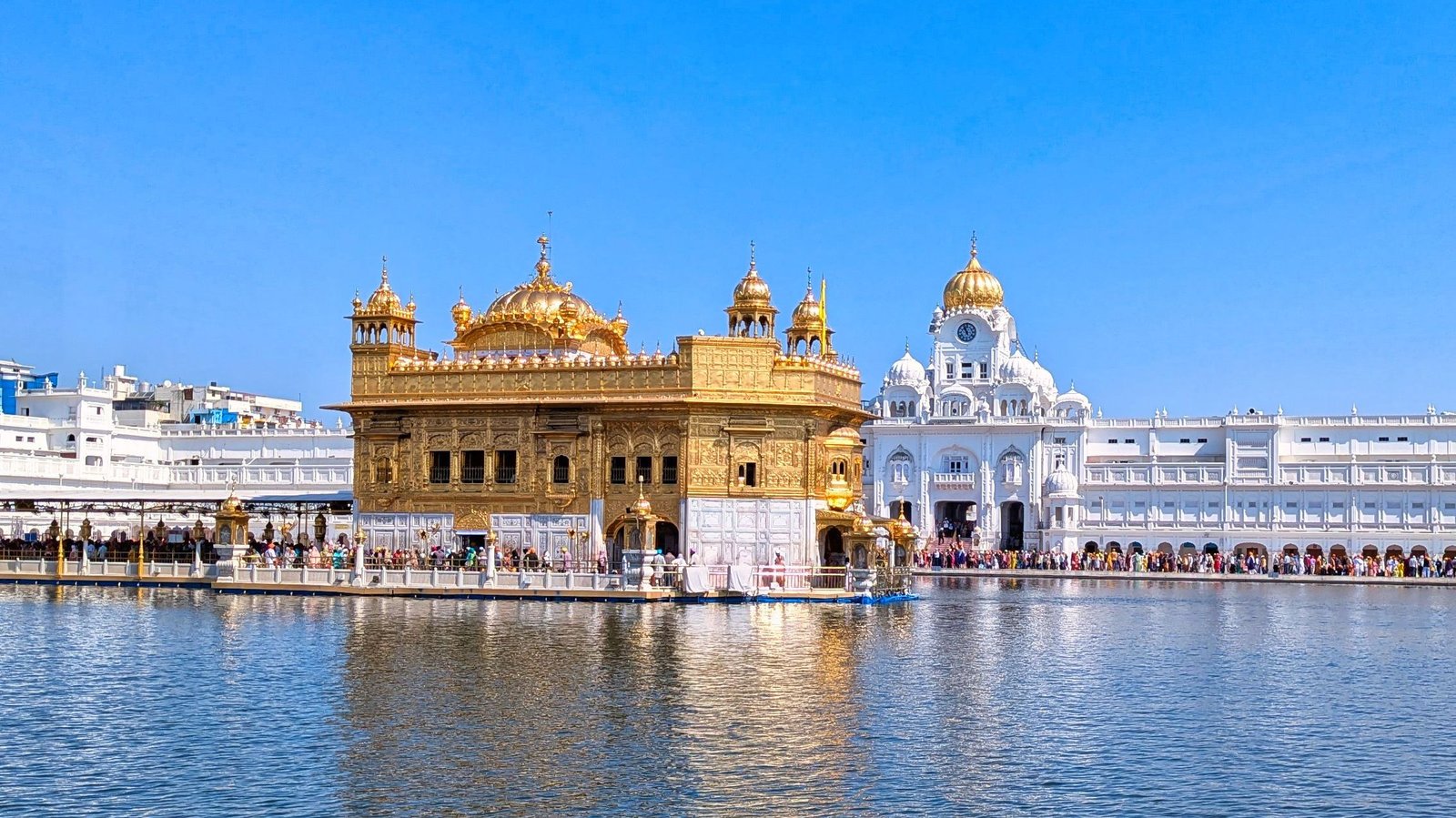 The Golden Temple in Amritsar reflected in the sacred pool under a clear blue sky
