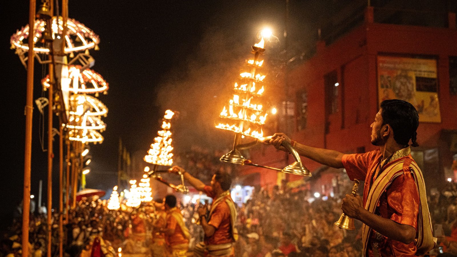 Priests performing the evening Ganga Aarti with brass lamps on the ghats of Varanasi